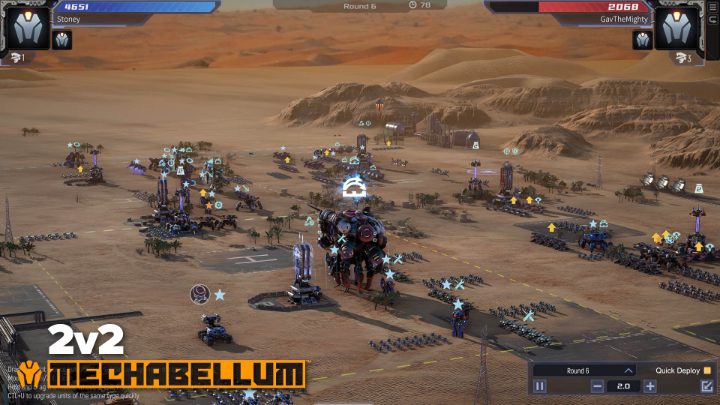 A 2v2 match shows blue and red mech forces across a desert battlefield.